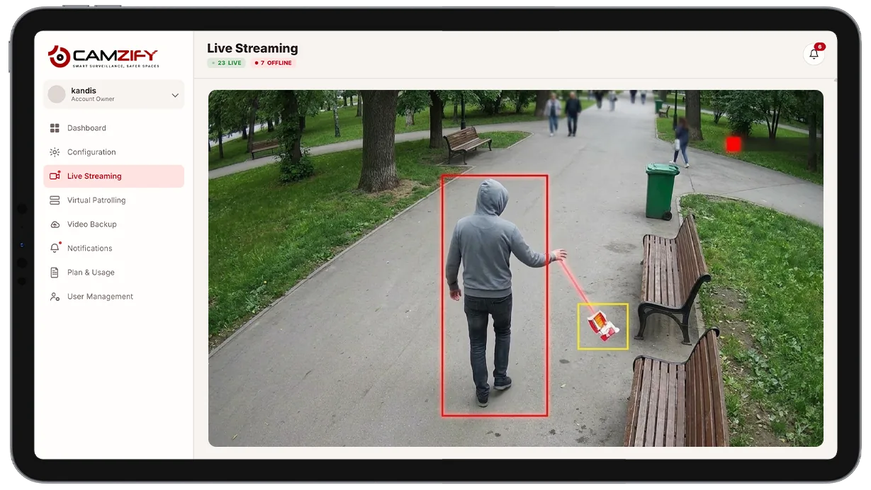 Camera view of an outdoor area with a littering event highlighted by a detection bounding box