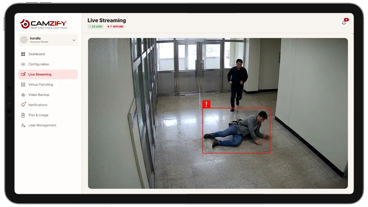 Camera view of a retail aisle with a fallen person highlighted by a detection bounding box