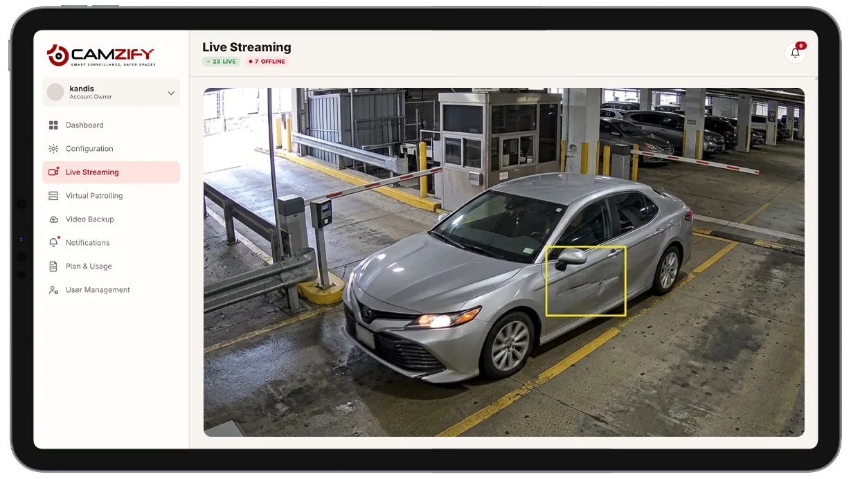 Camera view of a vehicle at an entry point with a highlighted area of exterior damage
